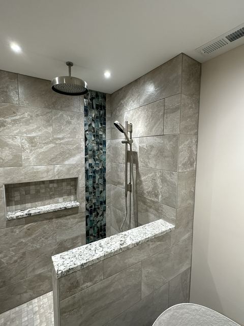 Walk-in shower with large-format tile and glass accent stripe