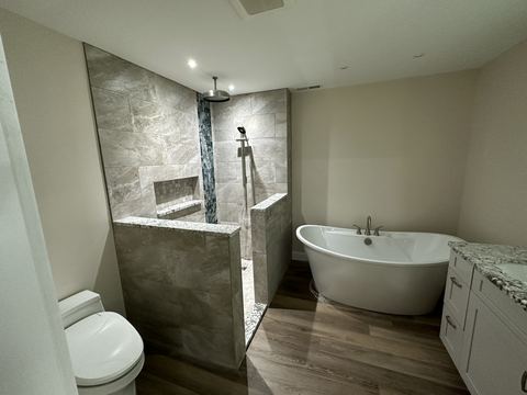 Remodeled bathroom with walk-in tile shower and freestanding tub