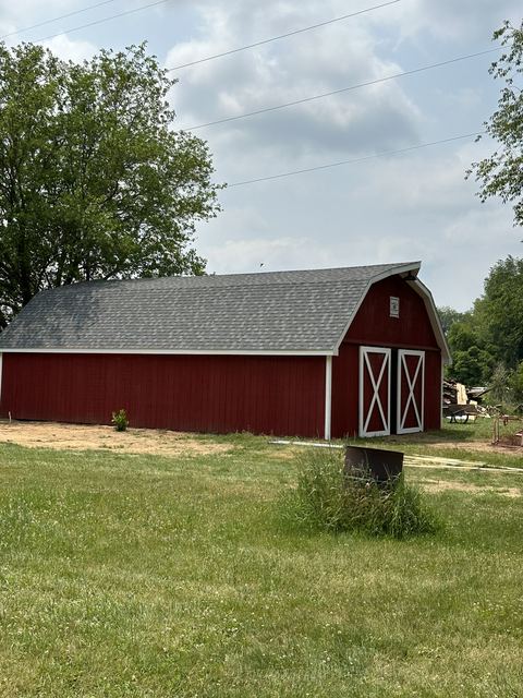 Red barn with new gray shingle roof