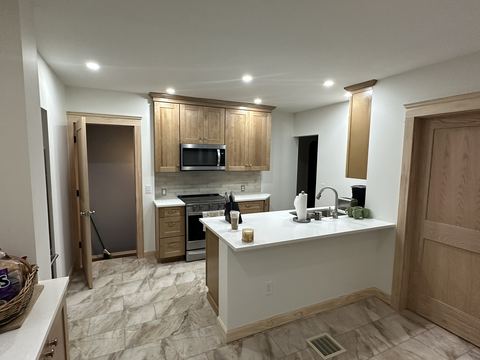 Remodeled kitchen with island and natural wood cabinets